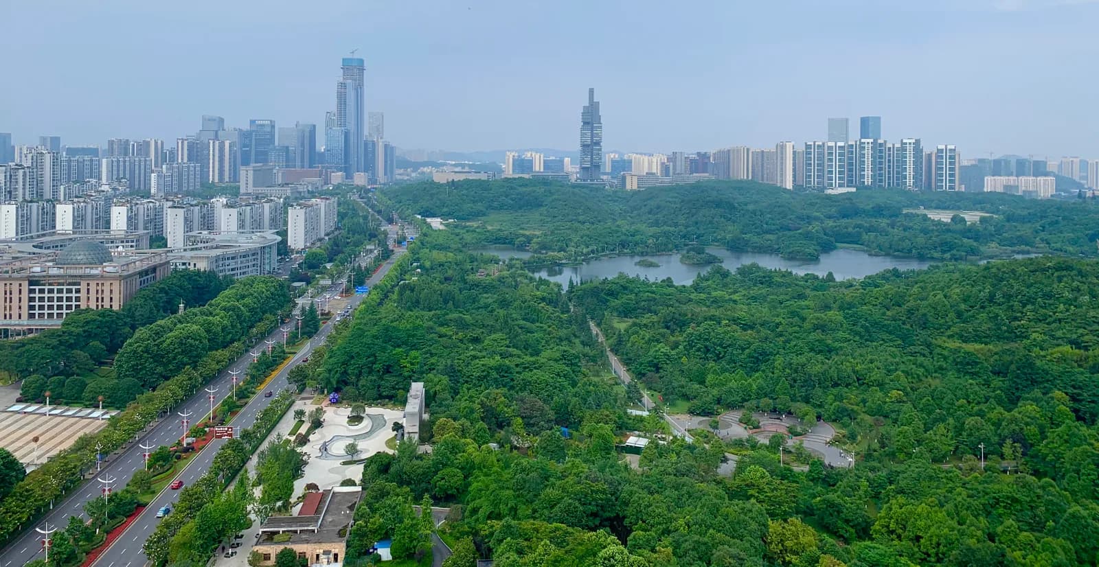 High-rise towers of central Guiyang stacked between green hills under a hazy sky